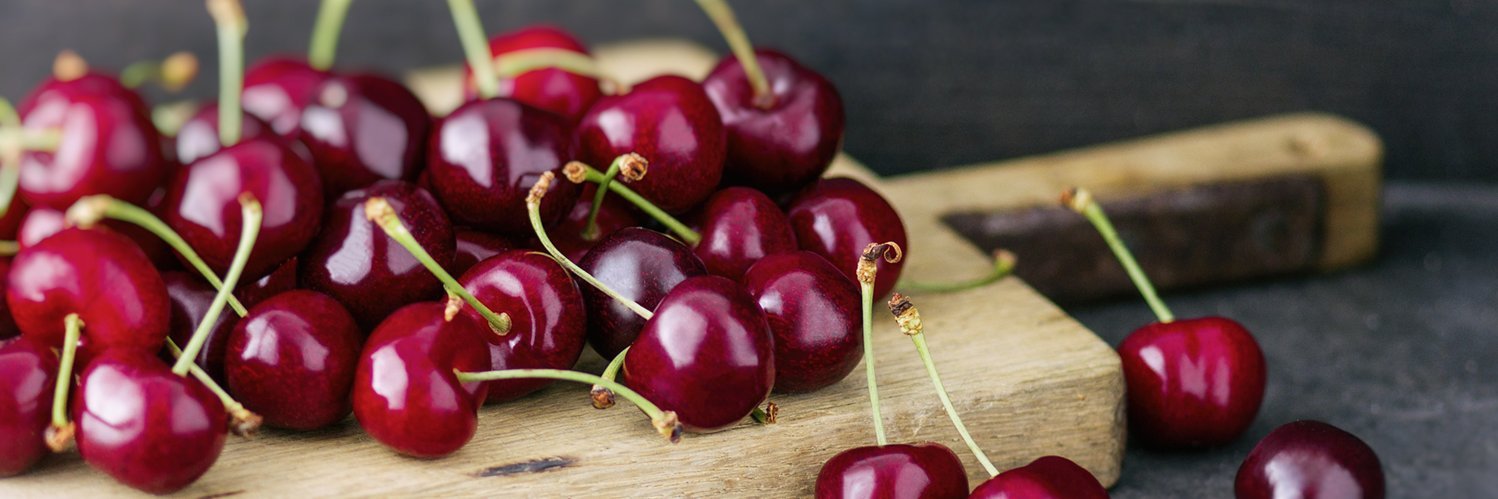 Rote Kirschen auf einem Holzbrett.