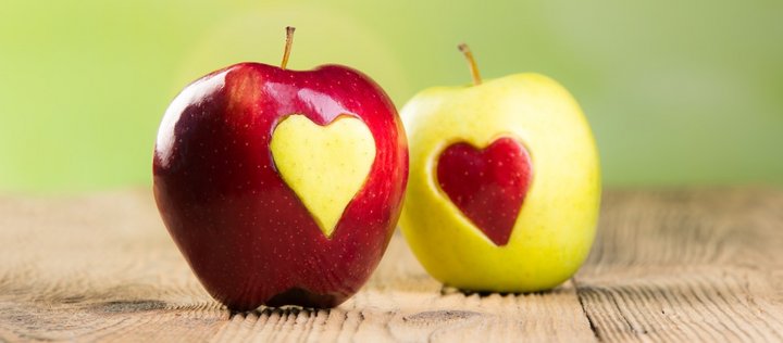 Ein roter Apfel mittig ein Herz aus einem hellem Apfel. Daneben ein heller Apfel der in der Mitte das Herz eines roten Apfels hat
