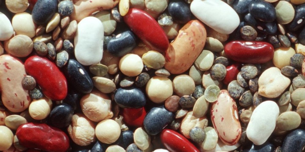 Verschiedene getrocknete Hülsenfrüchte liegen bunt durcheinander.