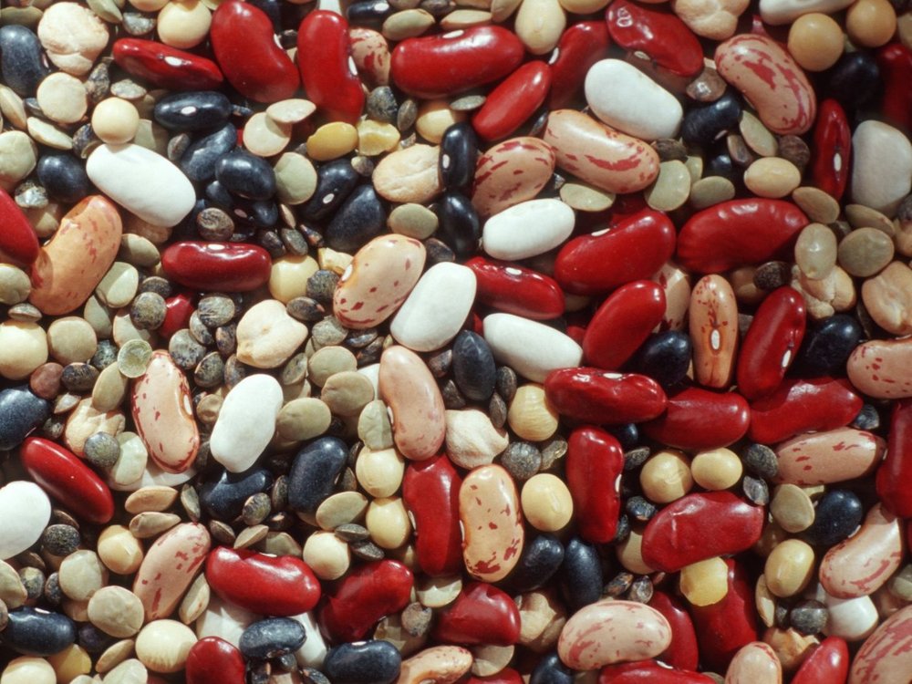 Verschiedene getrocknete Hülsenfrüchte liegen bunt durcheinander.