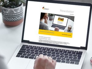 Frau sitzt vor Laptop.