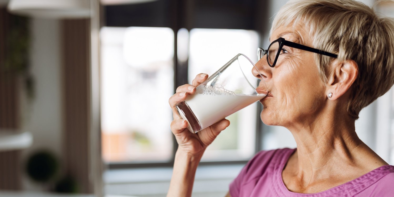 Eine ältere Frau mit grauen kurzen Haaren trinkt aus einem Glas Milch.. Artikel "Milch: Gesundheit und Umwelt" öffnen.