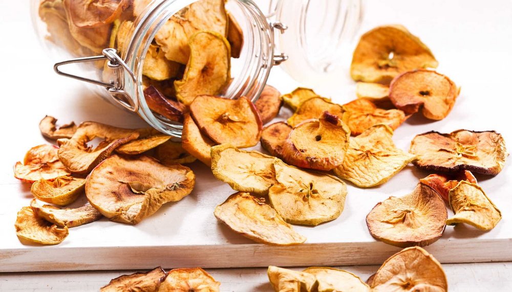 Getrocknete Apfelringe ergießen sich aus einem Glas