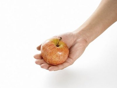 Eine Erwachsenenhand hält einen ganzen Apfel.