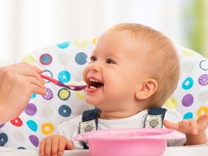Ein Baby wird mit Brei gefüttert.