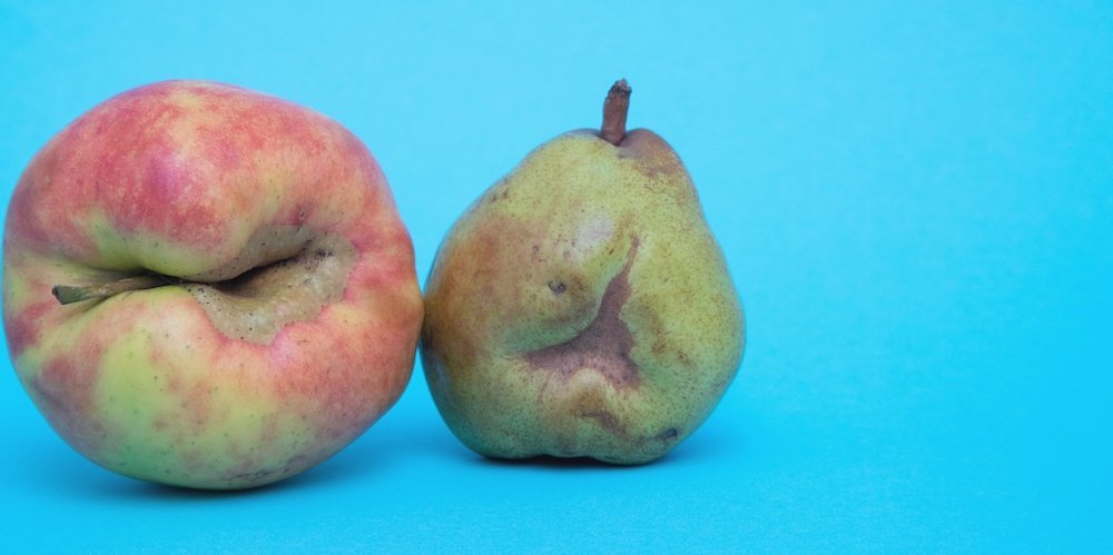 Ein Apfel und eine Birne mit natürlichen Verwachsungen.