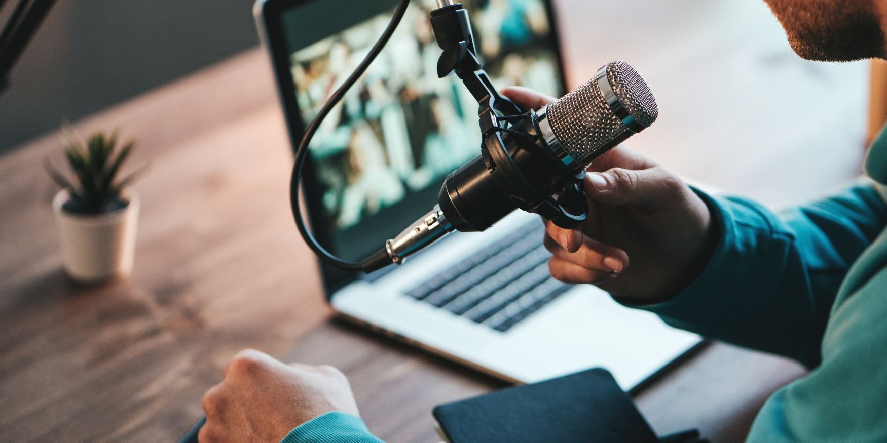 Ein Mann spricht in ein Mikrofon.. Artikel "Podcast" öffnen.