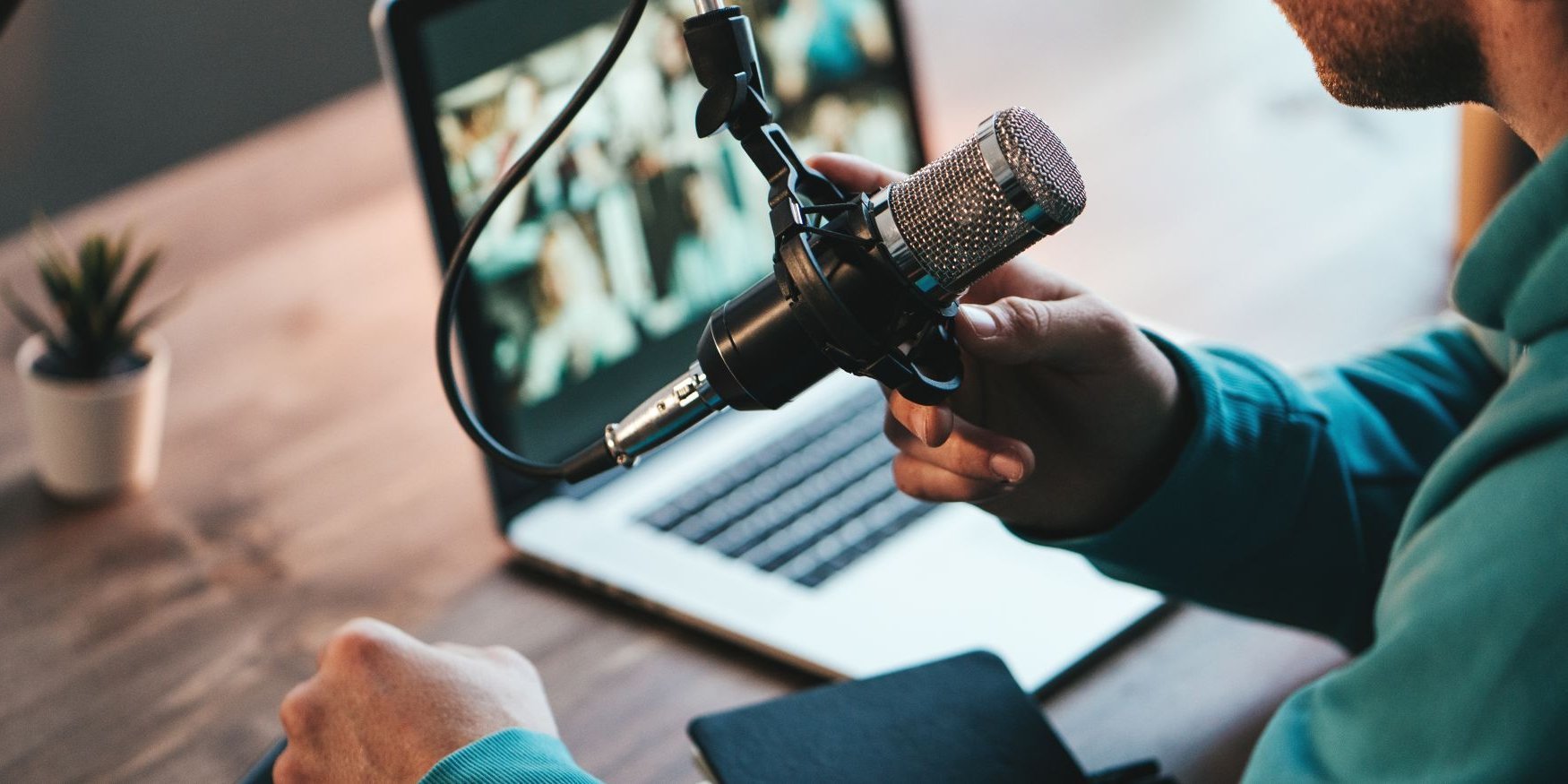 Ein Mann spricht in ein Mikrofon.. Artikel "Podcast" öffnen.