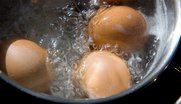 Drei braune Hühnereier im kochenden Wasser