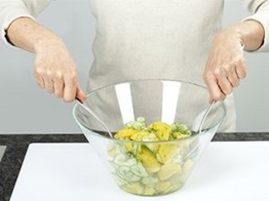 eine Person vermischt den Salat.