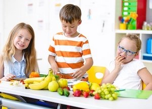 Drei Kinder im Grundschulalter bereiten Obst zu