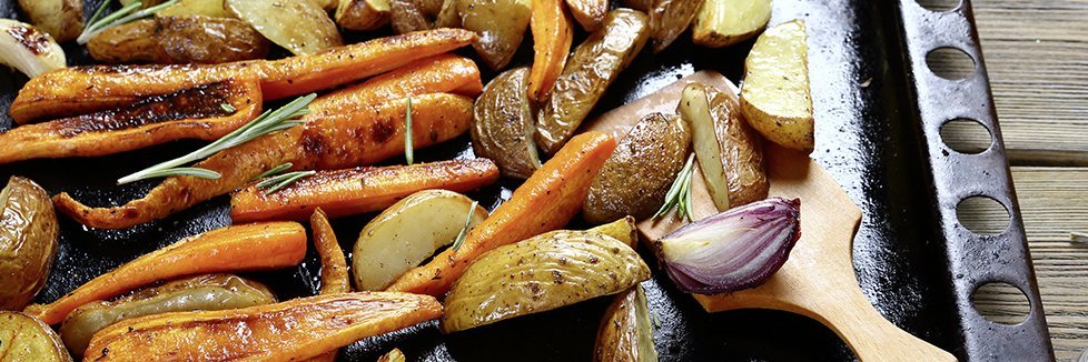 Kartoffeln und Gemüse liegen auf einem Backblech.