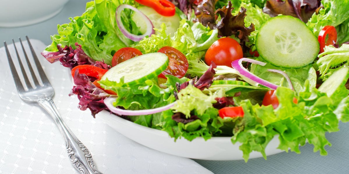 Neben einer Schuessel mit buntem Salat liegt eine Gabel.. Artikel "Salate: Vom Einkauf in die Küche" öffnen.