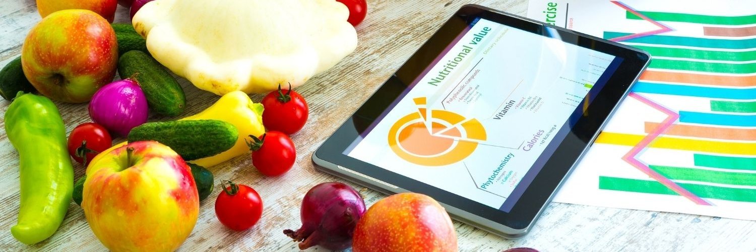 Auf einem Tisch liegt ein Tablett mit einer Grafik zu Nähwerten und daneben Äpfel, Zwiebeln, Paprika, Kürbis und Tomaten.