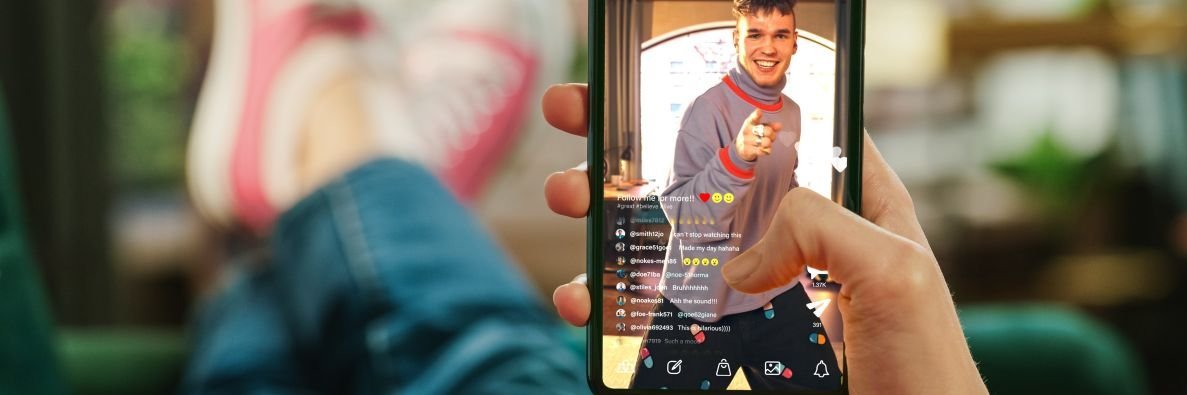 Person mit hochgelegten Beinen hält Handy in der Hand.