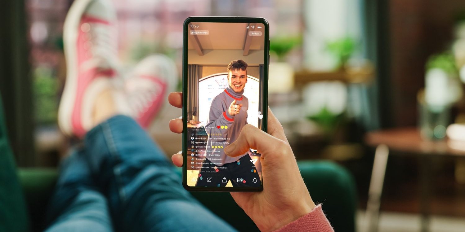 Person mit hochgelegten Beinen hält Handy in der Hand.. Artikel "Einfluss von Influencer-Werbung in den sozialen Medien auf Heranwachsende" öffnen.