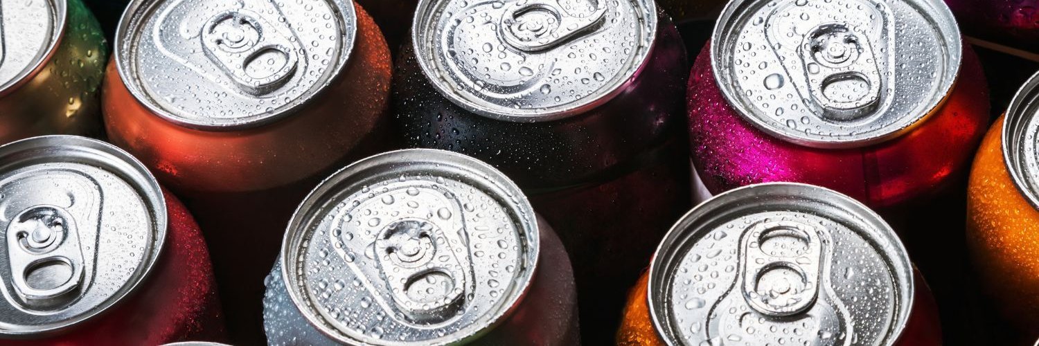 Das Bild ist ausgefüllt von Aluminium-Getränkedosen in der Ansicht von oben. 