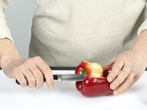 Eine Person entkernt rote Paprika.