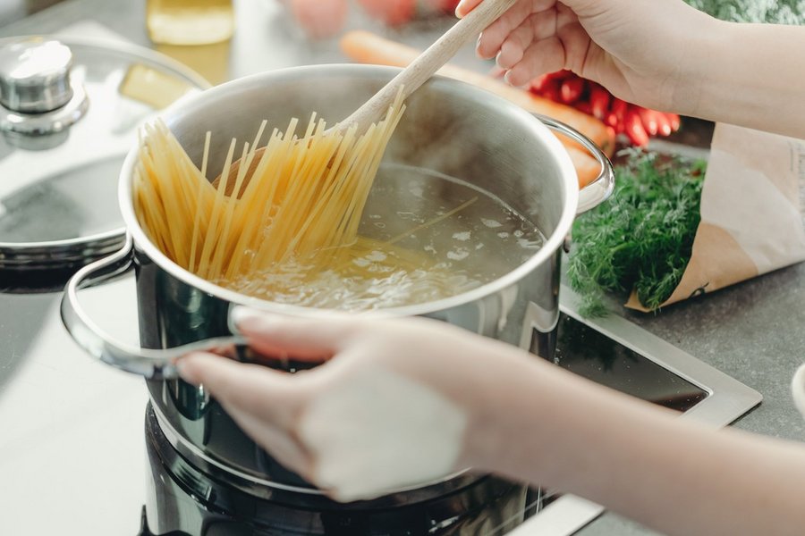 Spaghetti stehen aufrecht in einem Topf mit kochendem Wasser.