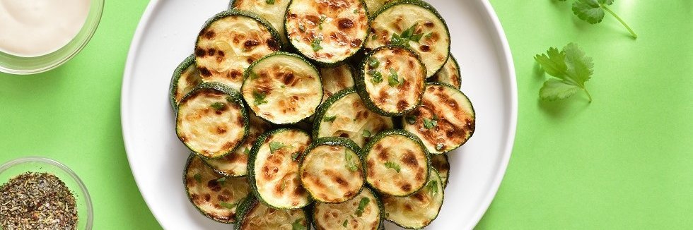 Gegrillte Zucchinischeiben auf einem Teller.