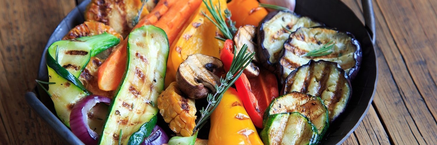 In einer Pfanne liegt buntes Grillgemüse – Zucchini, Paprika, Champignons, Möhren und Zwiebeln.