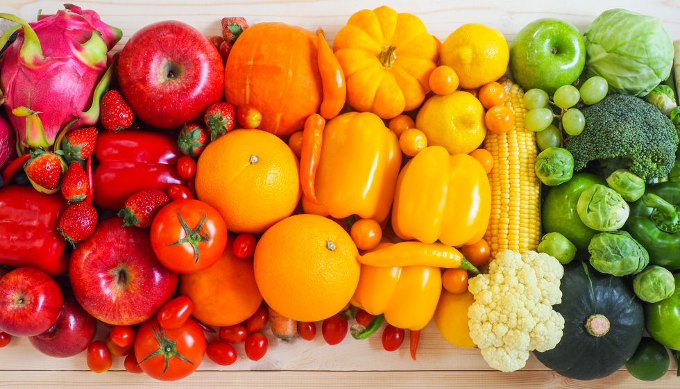 Verschiedene Gemüse- und Obstarten in Regenbogenfarben angeordnet