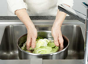 Person wäscht Salat