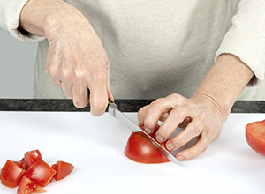 Person schneidet Tomaten