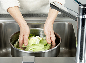 Person wäscht Salat