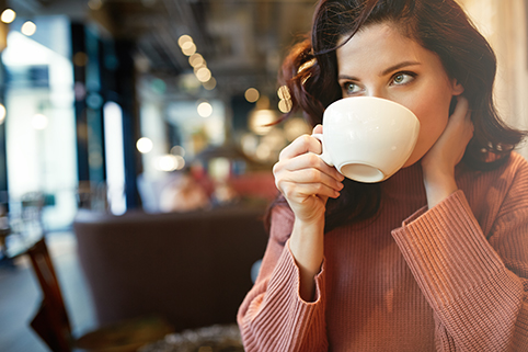 Bild: Eine Frau trinkt einen Kaffee.