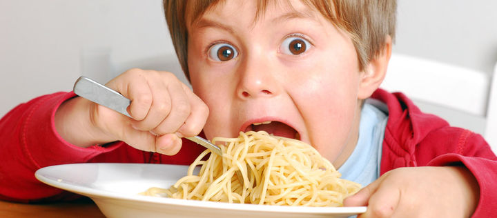 Junge mampft Spaghetti