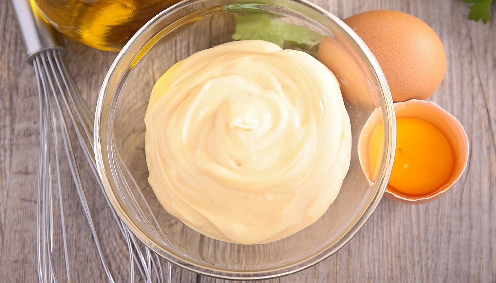 Mayonnaise in Schälchen mit Eier und Schneebesen daneben