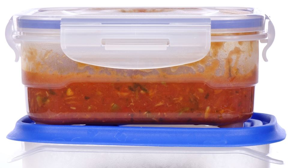 Kunststoffdosen mit Resten von Tomatensoße und Nudeln