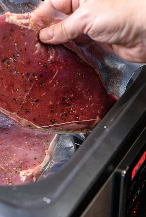 Vakuumiertes Steak wird in Sousvide-Garer gelegt