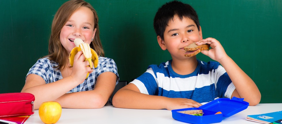 Zwei Kinder frühstücken im Klassenzimmer