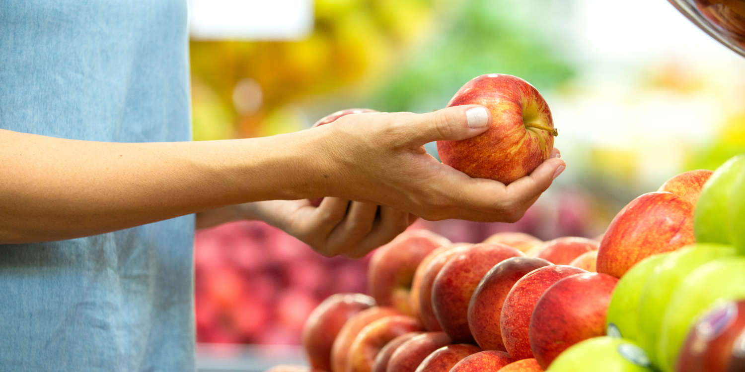 Frau am Apfelstand hält in der Hand einen Apfel.. Artikel "Äpfel: Vom Einkauf in die Küche" öffnen.