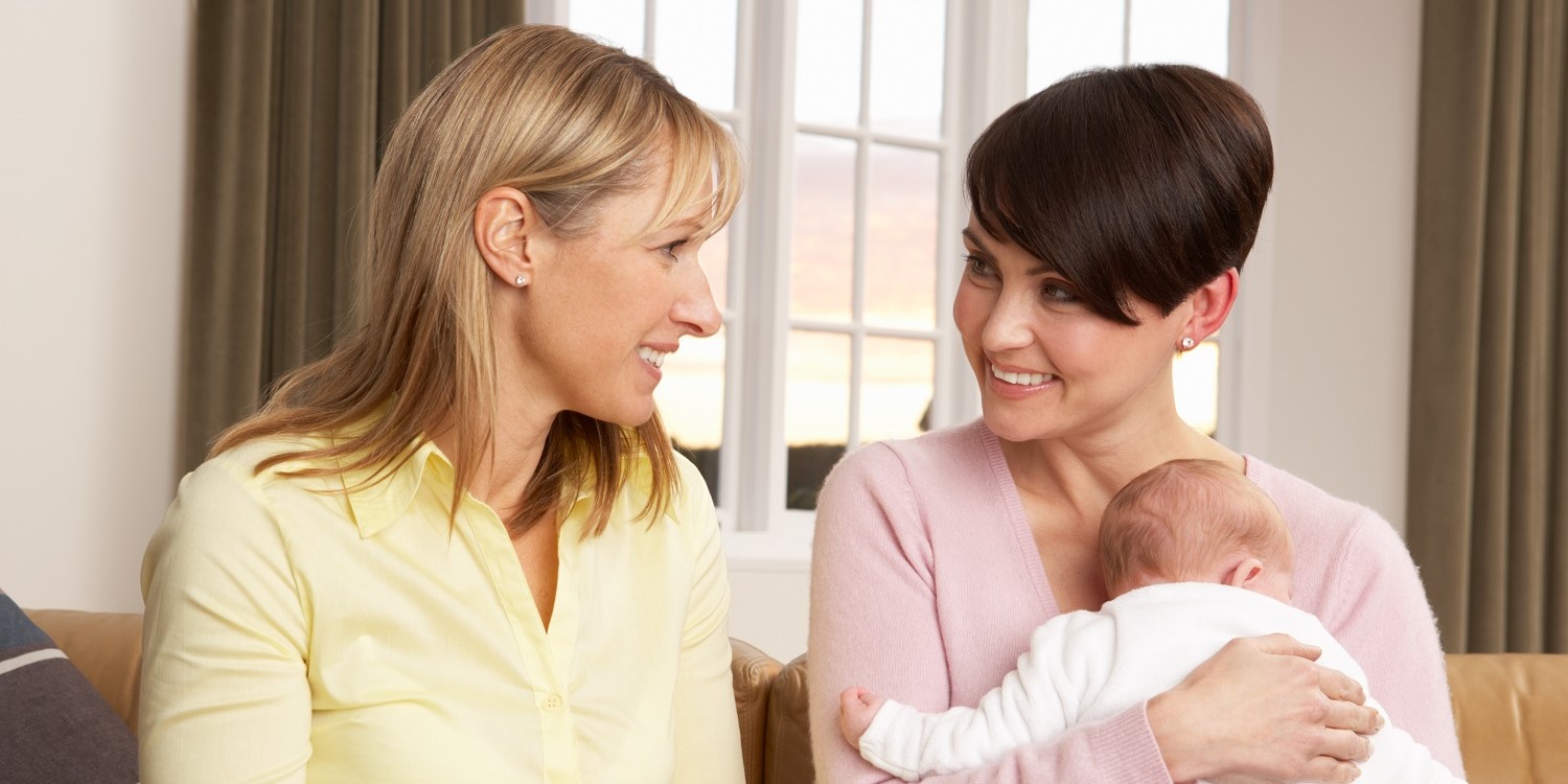 Eine junge Mutter mit ihrem Säugling auf dem Arm unterhält sich mit ihrer Hebamme. Artikel "Du entscheidest. Nicht die Werbung." öffnen.