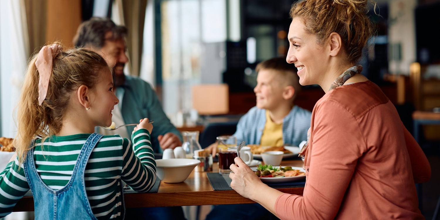 Eine Familie sitzt in einem Restaurant gemeinsam am Tisch und isst. . Artikel "Räuberteller statt Pommes mit Schnitzel" öffnen.