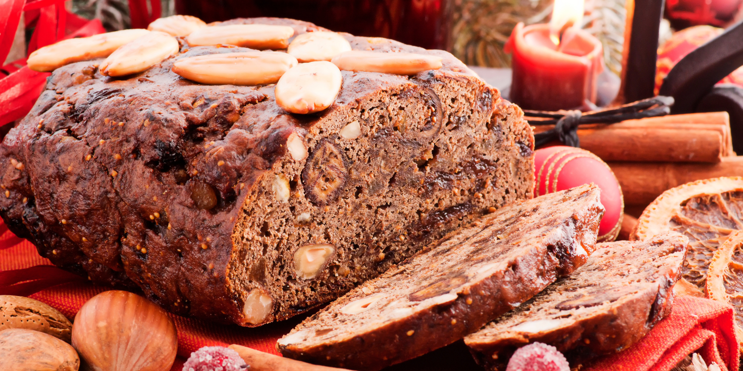 Ein Früchtebrot verziert mit Mandeln. Im Hintergrund liegt eine Weihnachtskugel und brennt eine Kerze. . Artikel "Früchtebrot für den Adventskaffee" öffnen.