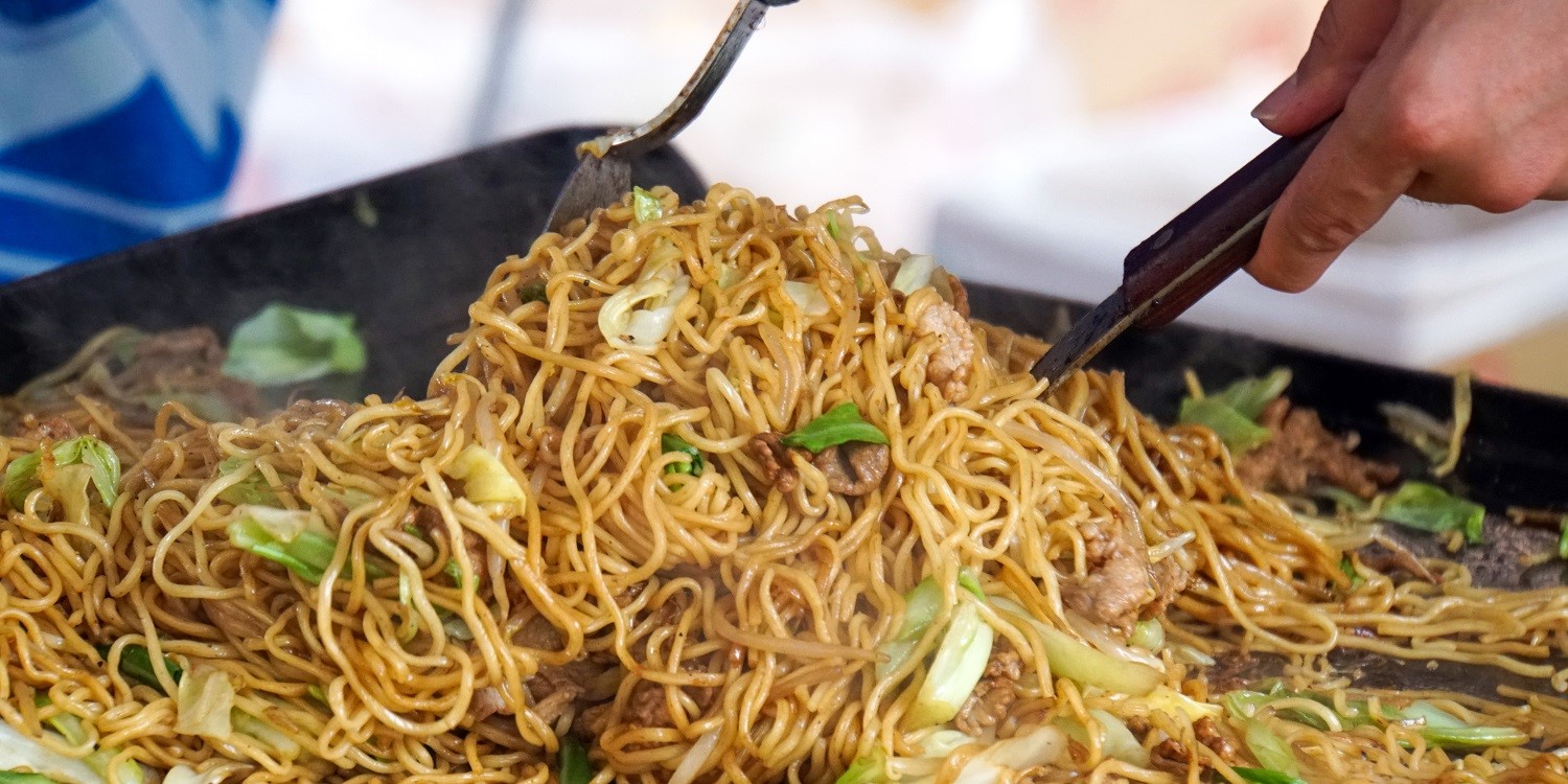 An einem Yatai-Stand in Japan wird das landestypische Nudelgericht „Yakisoba“ frisch zubereitet.. Artikel "Japanisches Streetfood" öffnen.
