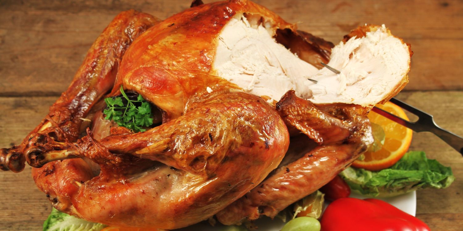 Von einem gebratenen Puter ist eine Scheibe Brust abgeschnitten und auf eine Fleischgabel gespießt.. Artikel "Putenbraten zum Weihnachtsfest" öffnen.