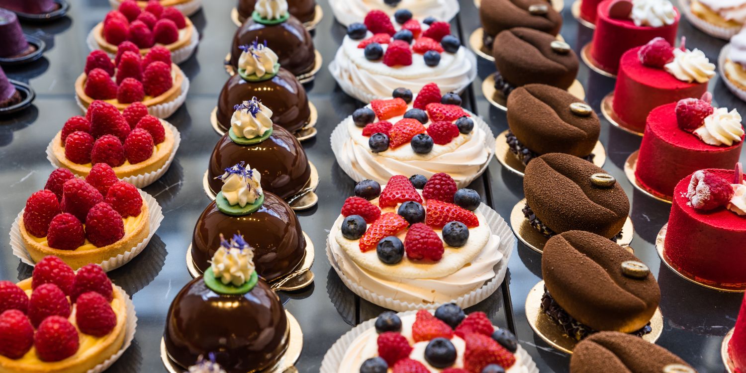 In der Theke eine Konditorei liegen verschiedene Törtchen mit Obst, Schokolade und Sahne. . Artikel "Versteckter Alkohol in Lebensmitteln" öffnen.