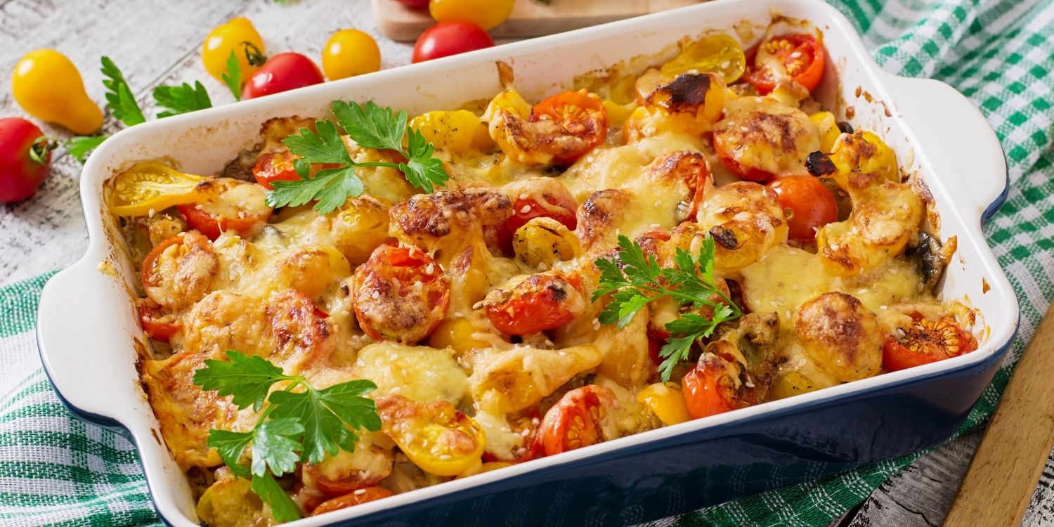 In einer weißen eckigen Auflaufform sind Tomaten, Zucchini und Pilze mit Käse überbacken und mit Petersilie dekoriert.. Artikel "Wohlfühlessen aus dem Ofen" öffnen.