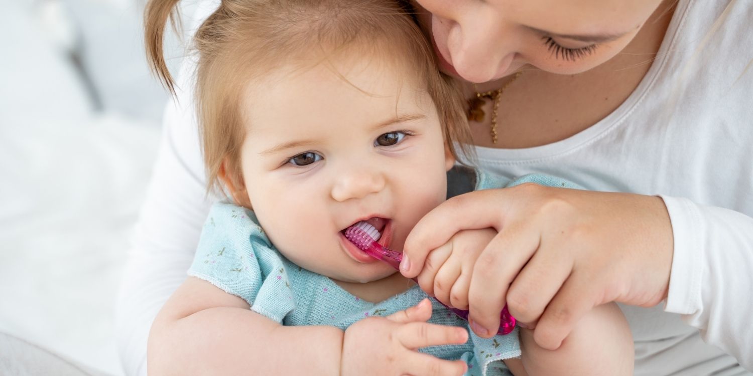 Eine Mutter putzt ihrer etwa einjährigen Tochter die Zähne. . Artikel "Kinderzähne von Geburt an schützen" öffnen.