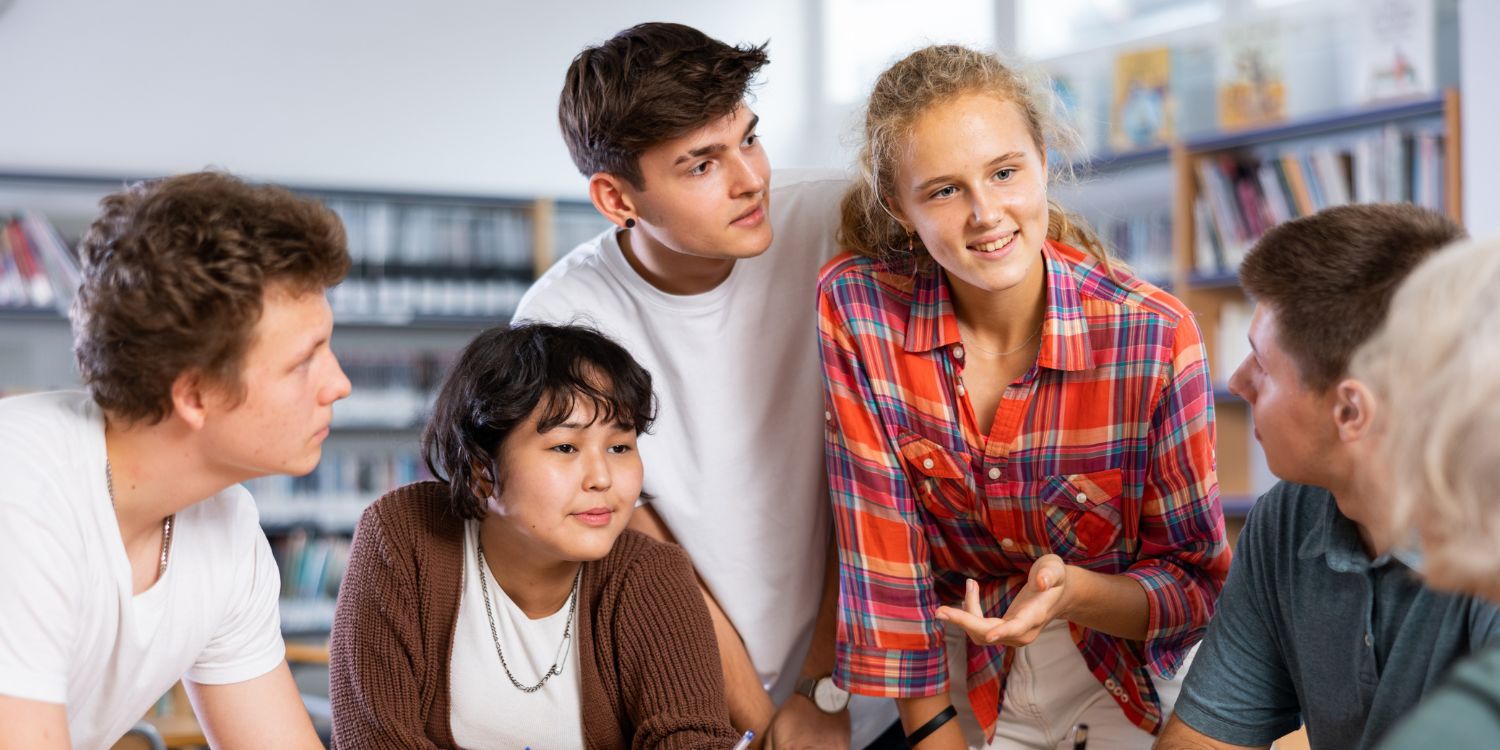 Eine Gruppe von Schülerinnen und Schülern verschiedenster Nationalitäten diskutiert an einem Tisch. . Artikel "Einfache Sprache in der Bildung" öffnen.