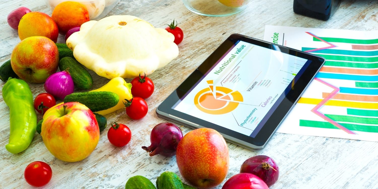 Auf einem Tisch liegt ein Tablett mit einer Grafik zu Nähwerten und daneben Äpfel, Zwiebeln, Paprika, Kürbis und Tomaten.. Artikel "Glaubwürdige Ernährungsinfos finden" öffnen.