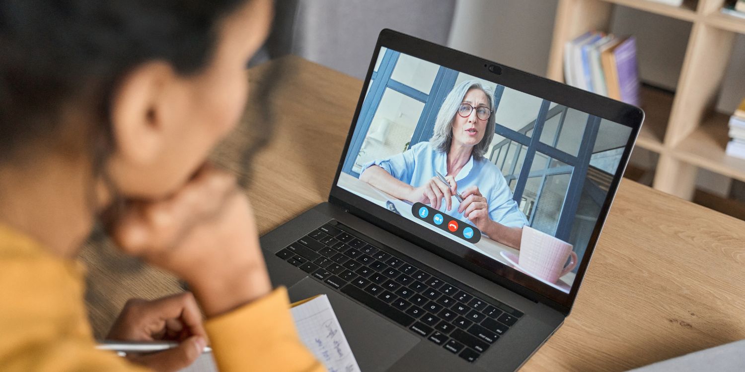 Eine junge dunkelhaarige Frau sitzt vor einem Laptop. Auf dem Bildschirm hält eine ältere grauhaarige Frau einen Vortrag.. Artikel "Web-Seminare zur Säuglingsernährung" öffnen.