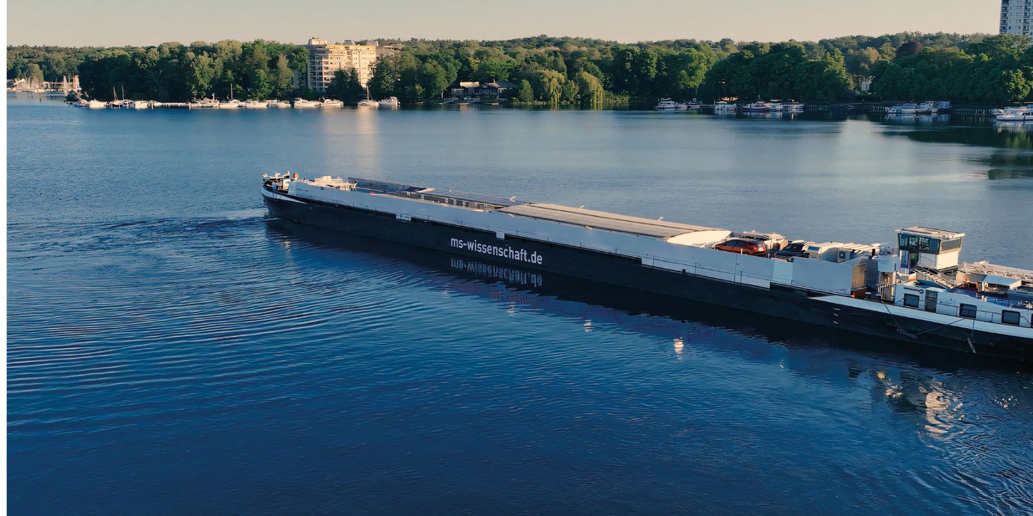 Das Ausstellungsschiff MS Wissenschaft fährt auf einem Fluss.. Artikel "Burger-Check an Bord" öffnen.