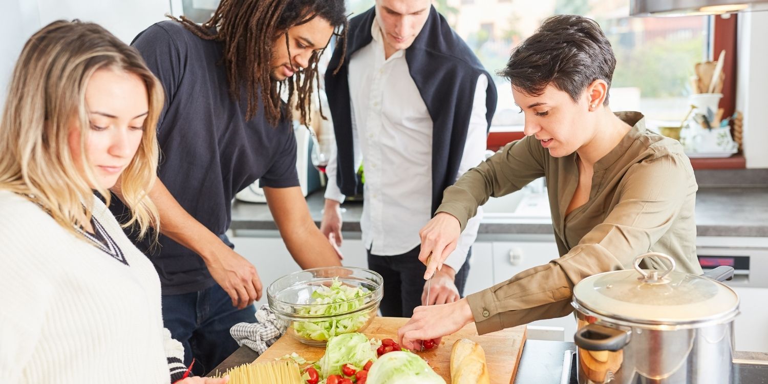 Vier junge Erwachsene bereiten in einer Küche zusammen Salat und Spaghetti zu.. Artikel "Lebensstil bei US-Studierenden wirkt offenbar Jahrzehnte nach" öffnen.